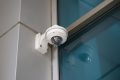 Dome surveillance camera on a wall bracket at a building corner