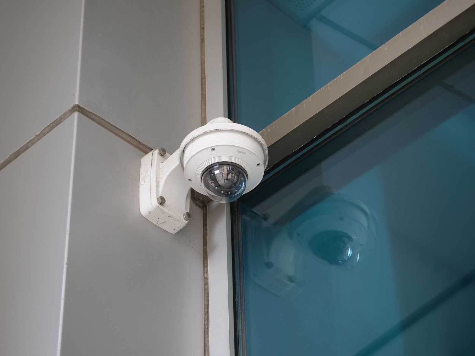 Dome surveillance camera on a wall bracket at a building corner