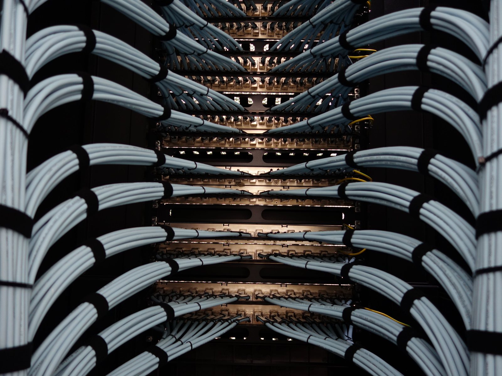 Neatly dressed horizontal cabling looms entering a rack row