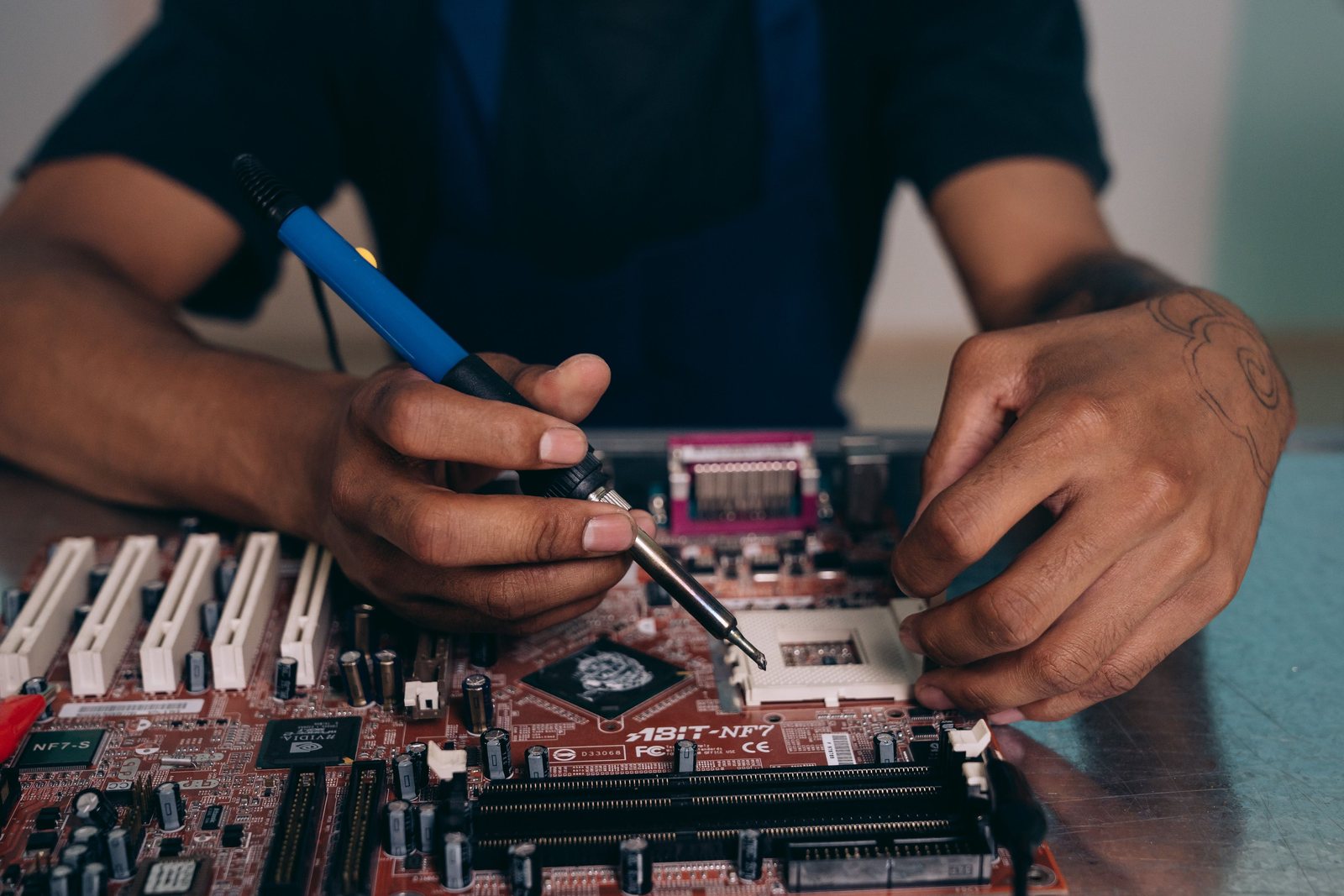 Technician hands working on a computer motherboard at a service bench