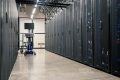 Server room aisle with closed racks and a crash-cart workstation