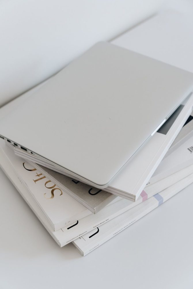 Closed laptop on a stack of documents, representing endpoint asset records