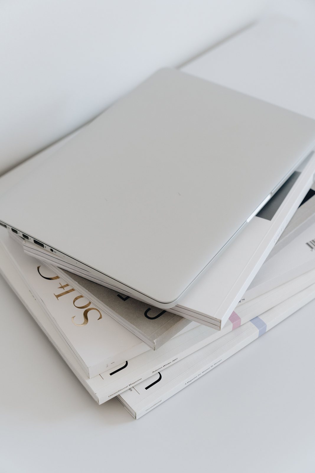 Closed laptop on a stack of documents, representing endpoint asset records