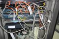 Network cabinet before migration: patch panels, stacked switches and tagged patch cords awaiting re-termination