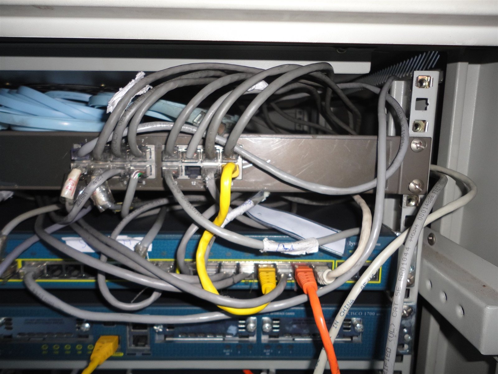 Rack before tidy-up: unmanaged patch cords looping over a patch panel and switches, the condition a hygiene pass corrects